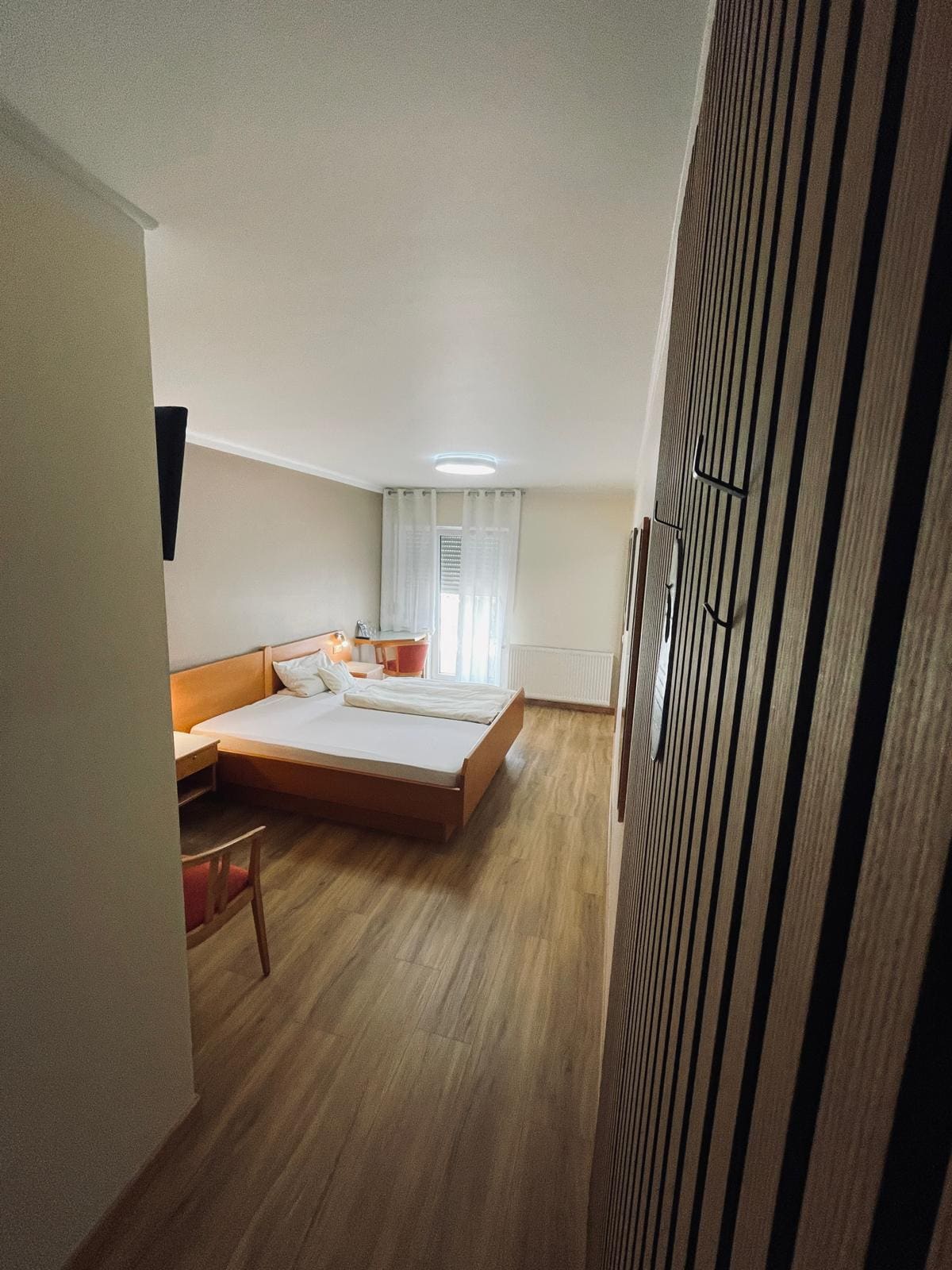Doppelzimmer zur Einzelnutzung im Landhaus Schend mit Holzbett, Holzboden und Lamellen-Kleiderschrank